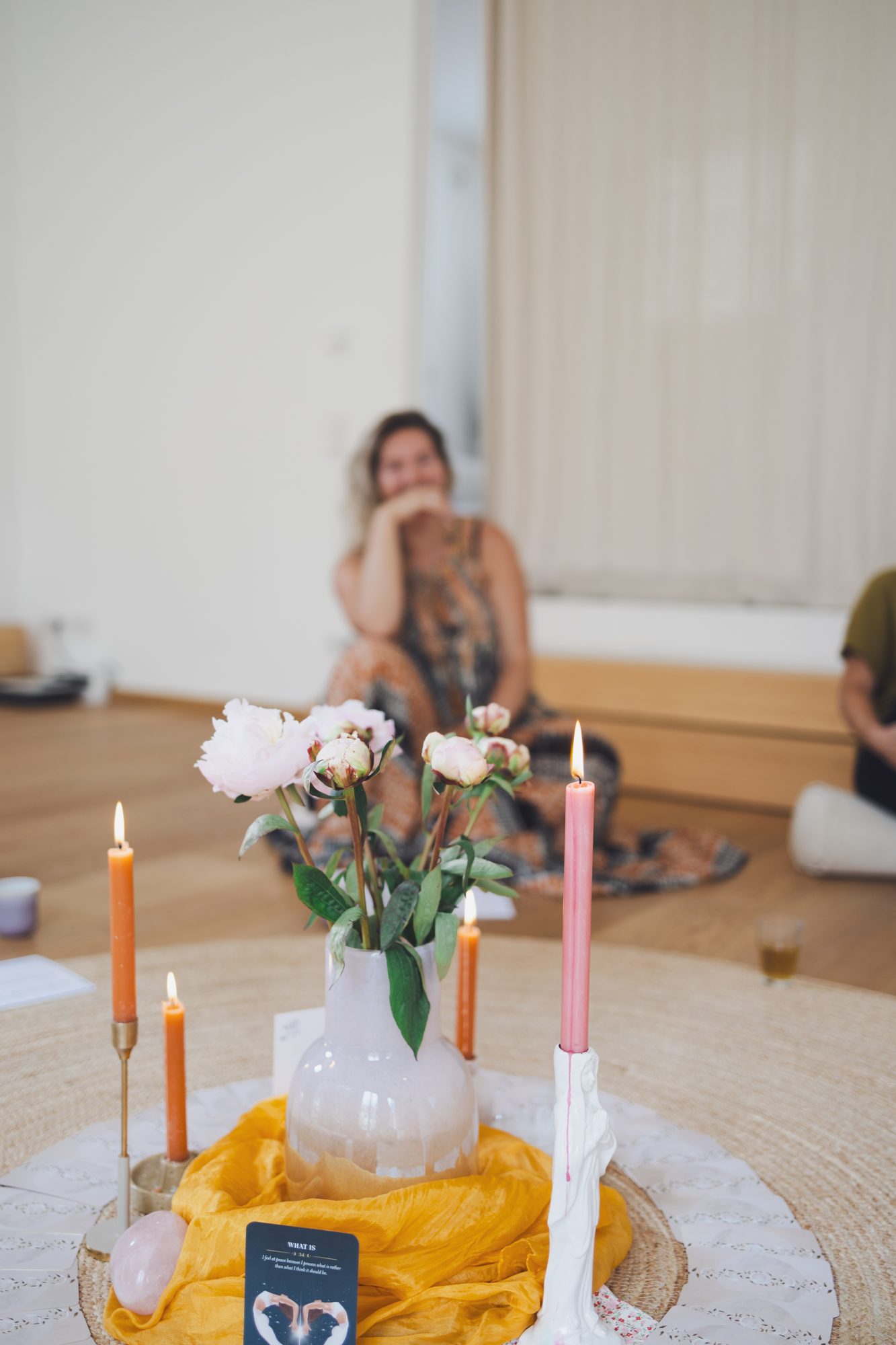 Frauen im Kreis mit Kerzen und Blumen