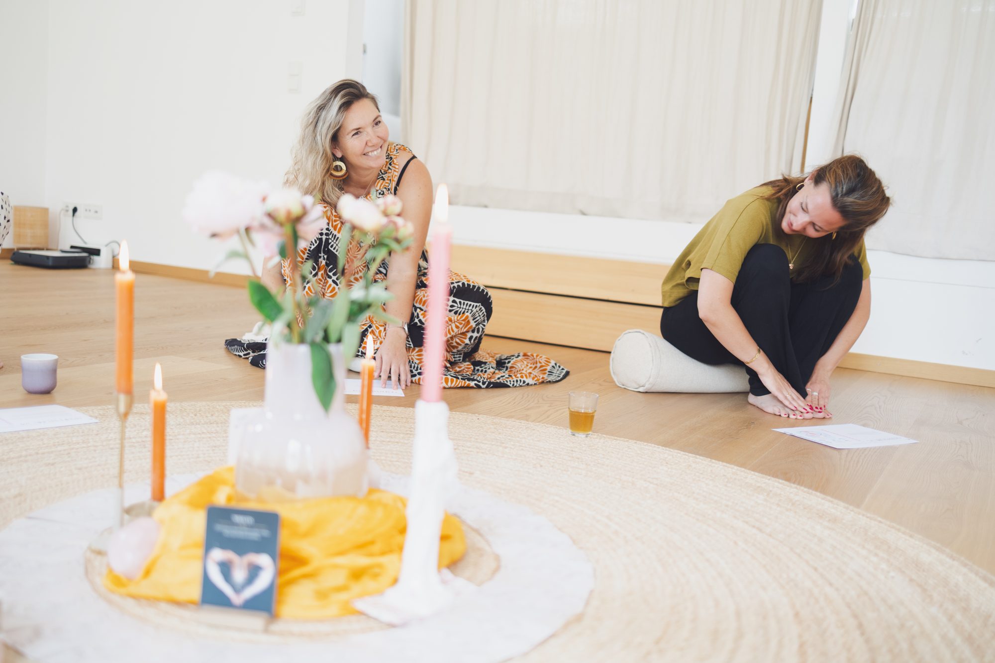 Zwei Frauen am Boden mit Kerzen